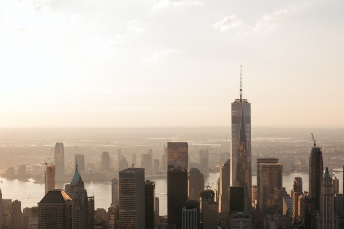 City skyline with a prominent skyscraper during sunset.