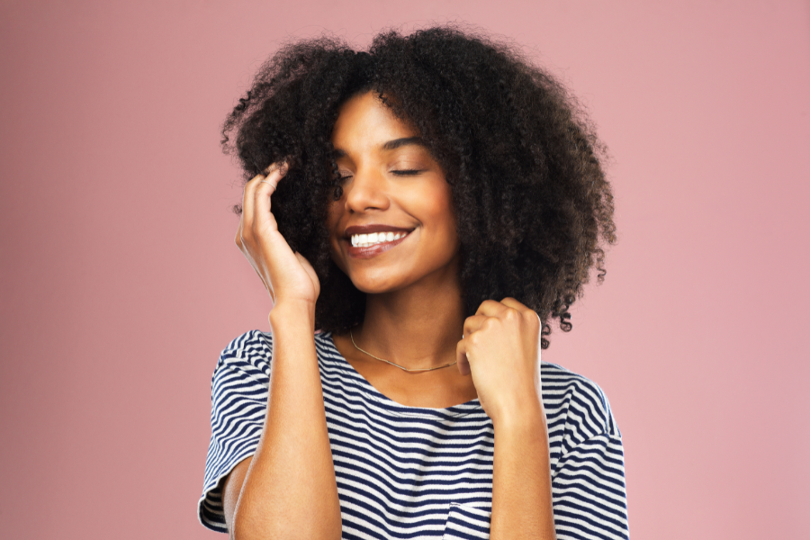 Woman with an afro hairstyle against a pink background